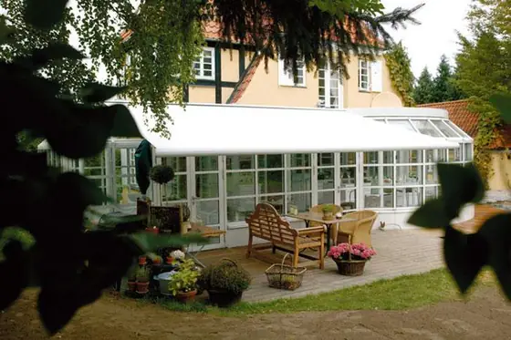 Breite Markise über einer Gartenterrasse