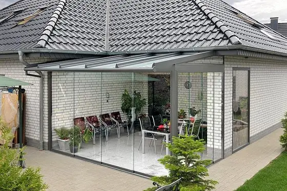 Terrassenüberdachung aus Aluminium mit Glasdach an einem Einfamilienhaus