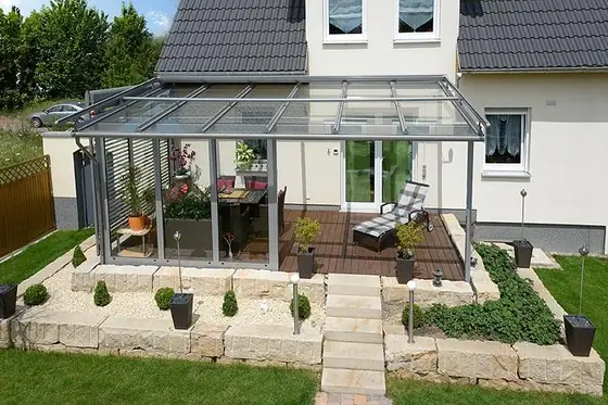 Terrassendach mit weißen Profilen an einer verputzten Fassade