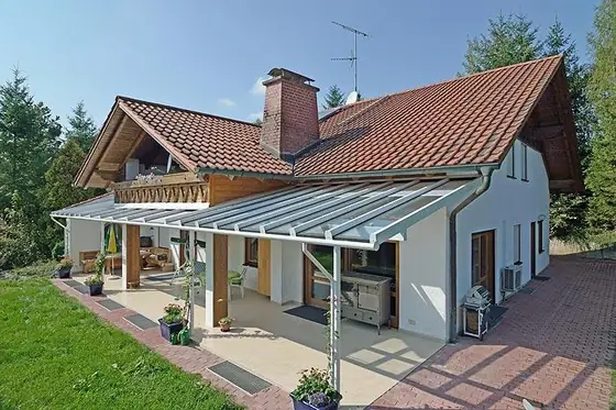 Überdachte Terrasse mit Holzdeck und Rasenfläche