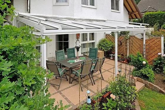 Terrassendach mit Blick auf eine Hecke und Beete