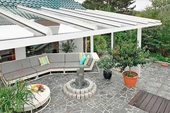 Terrassendach über einer Terrasse mit Natursteinbelag