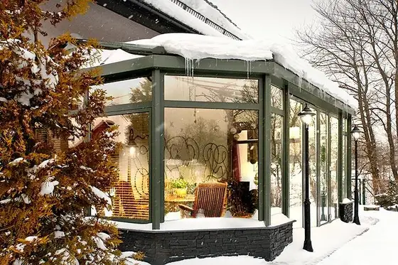 Wintergarten mit Esstisch unter dem Glasdach