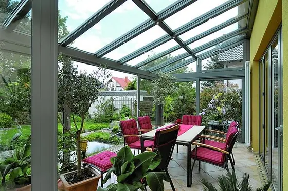 Wintergarten mit Loungemöbeln und Blick ins Grüne