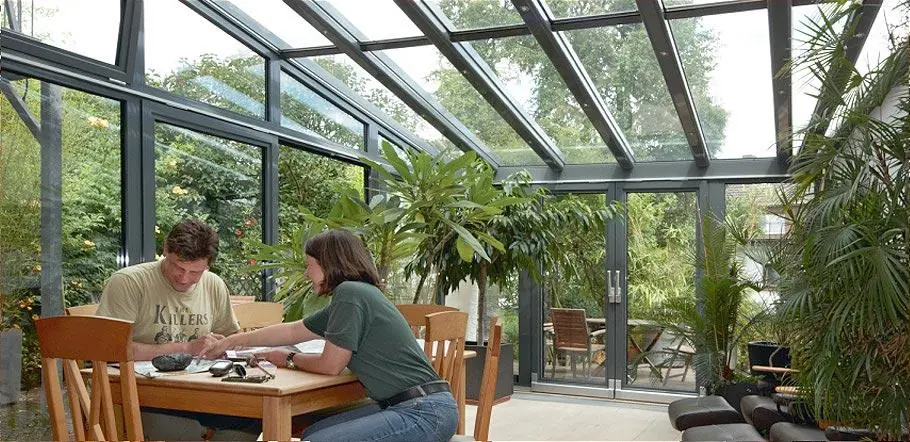 Wintergarten mit Pflanzen als Übergang zum Garten